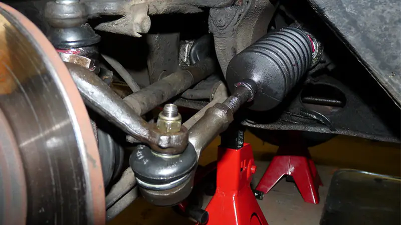 Instrumented steering assembly showing separate measurement references for rack housing, subframe, linkage joint and wheel angle