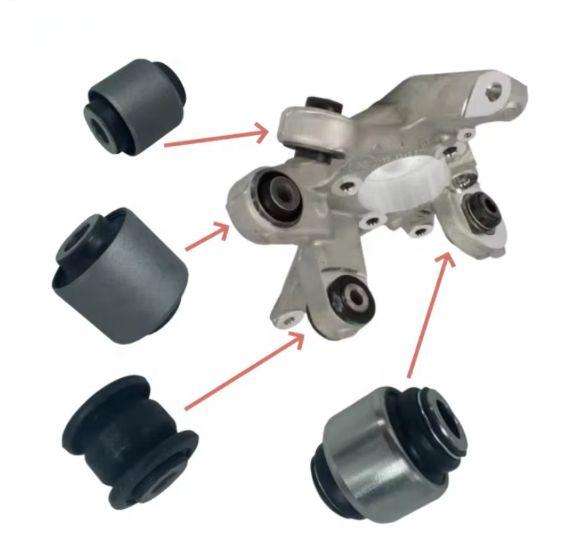 Two cross-sections comparing a bushing pressed into a wheel-carrier bore with a bushing pressed into a suspension-link eye and clamped to the carrier