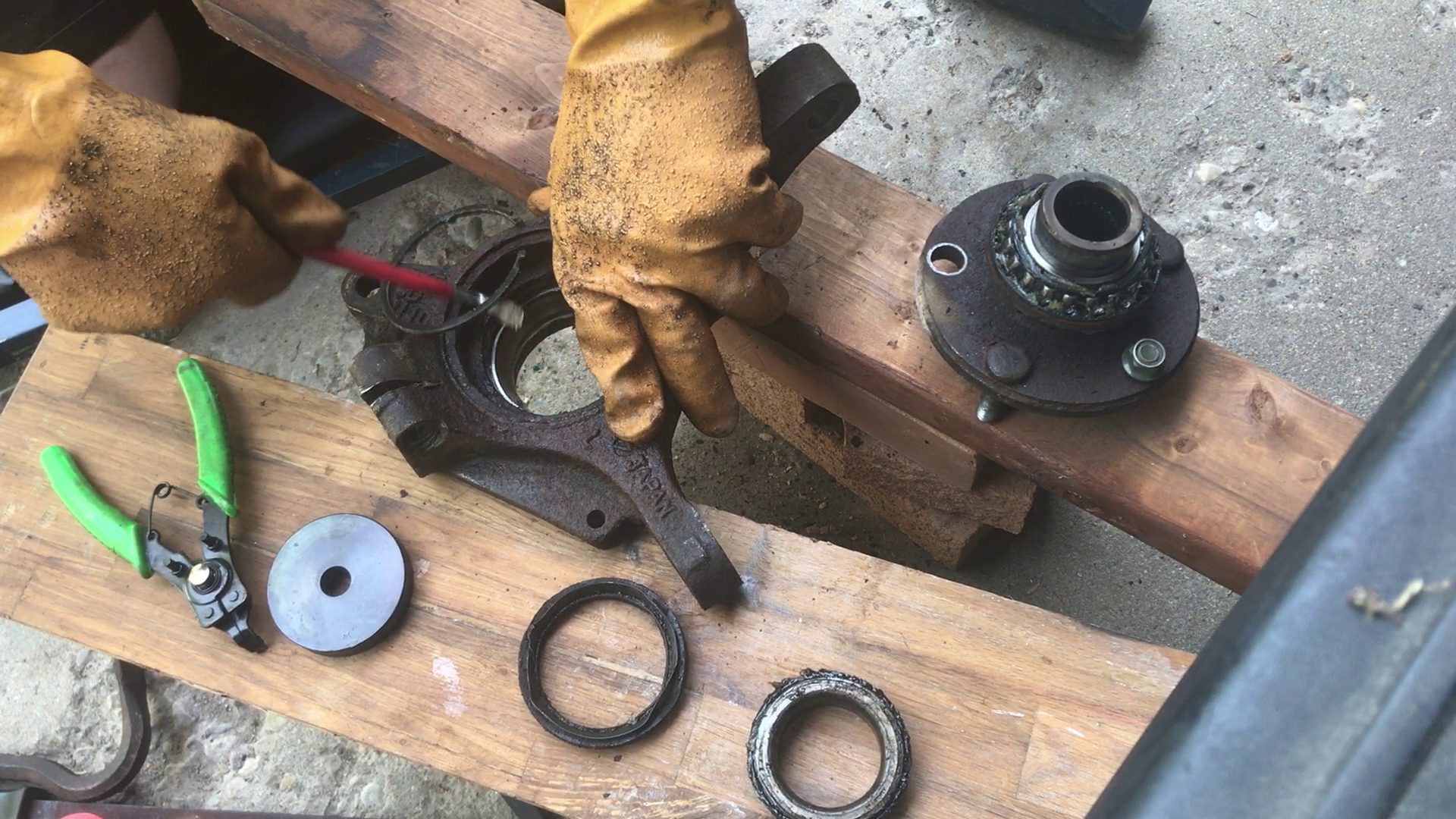 Technician inspecting a wheel-carrier bushing at normal ride height