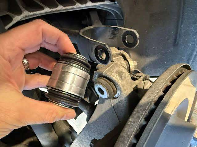 Dial indicator setup measuring relative knuckle-to-link movement under a controlled load.